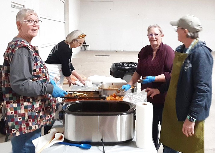 Volunteers with SAVE Meant-to-Rescue (SAVE-MTR), a local animal rescue organization, make enchiladas for a holiday fundraiser Nov. 24. Proceeds raised from the event went toward rescuing small animals. (Submitted photo)