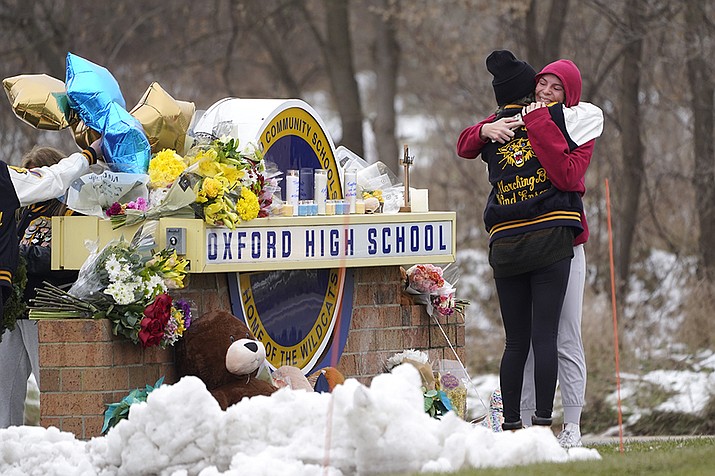 Students hug at a memorial at Oxford High School in Oxford, Mich., Wednesday, Dec. 1, 2021. Authorities say a 15-year-old sophomore opened fire at Oxford High School, killing four students and wounding seven other people on Tuesday. (Paul Sancya/AP)