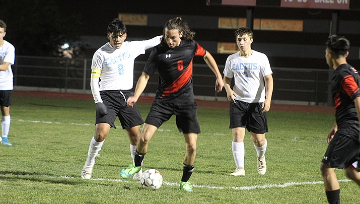 Lee Williams soccer player Beauen Bratley fights for possession during the Volunteers’ 3-1 win over Cactus High School on Tuesday, Nov. 30. (Miner file photo)