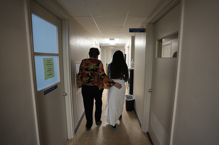 A 33-year-old mother of three from central Texas is escorted down the hall by clinic administrator Kathaleen Pittman prior to getting an abortion, Saturday, Oct. 9, 2021, at Hope Medical Group for Women in Shreveport, La. The woman was one of more than a dozen patients who arrived at the abortion clinic, mostly from Texas, where the nation's most restrictive abortion law remains in effect. (Rebecca Blackwell/AP, File)