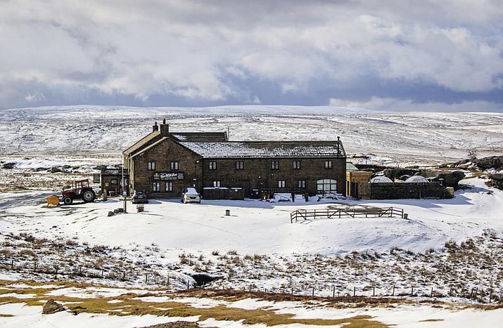 The Tan Hill Inn, following fresh snow fall, in Richmond, Yorkshire Dales, England, Saturday March 13, 2021. Customers who stopped for a drink at Britain’s highest pub got a longer stay than they bargained for recently, after the building was cut off by a blizzard. (PA via AP, File)