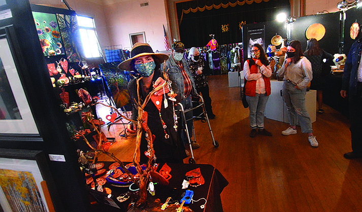 Artists returned for the 2021 Made In Clarkdale Artists Showcase on Friday, Dec. 3, 2021. Jenny Emminger, left, hangs her artwork before the show. (Verde Independent/Vyto Starinskas)