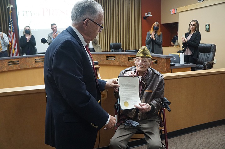 Prescott resident Ed Parry, seated right, a veteran of World War II, was honored by the Prescott City Council this past week during the city’s remembrance of the 80th anniversary of the Dec. 7, 1941, attack on Pearl Harbor. He received the city proclamation remembering Pearl Harbor from new Prescott Mayor Phil Goode, left. (Cindy Barks/Courier)