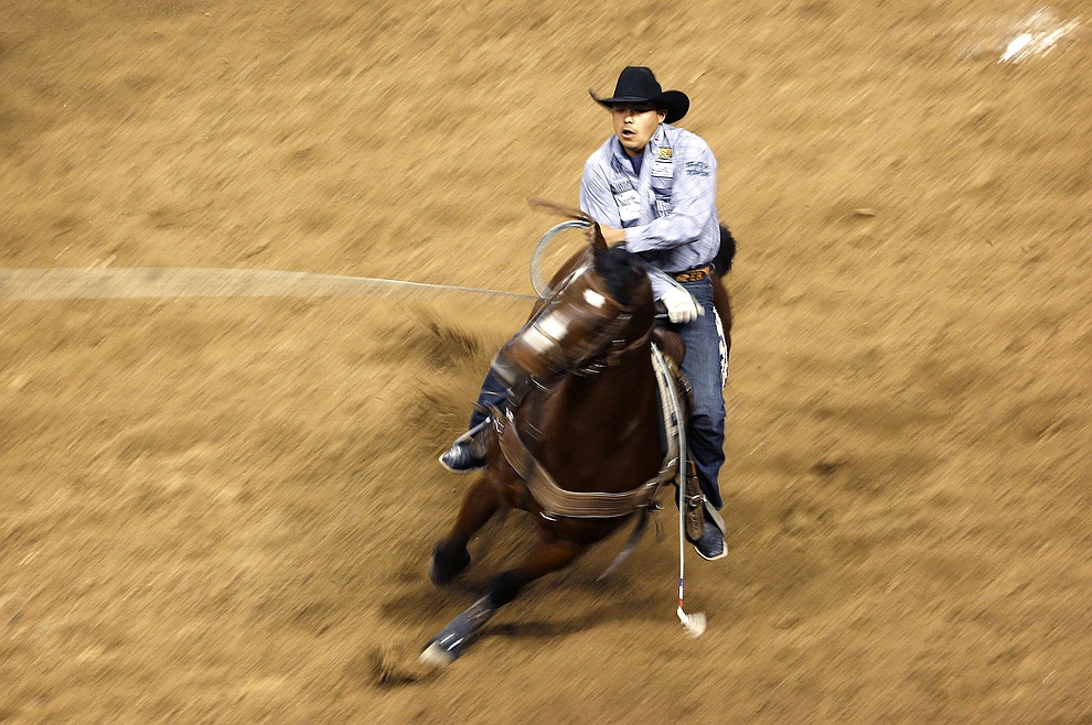 Erich Rogers competes in the team roping event during the seventh go-round of the National Finals Rodeo, Wednesday, Dec. 9, 2015, in Las Vegas. (AP Photo/John Locher)