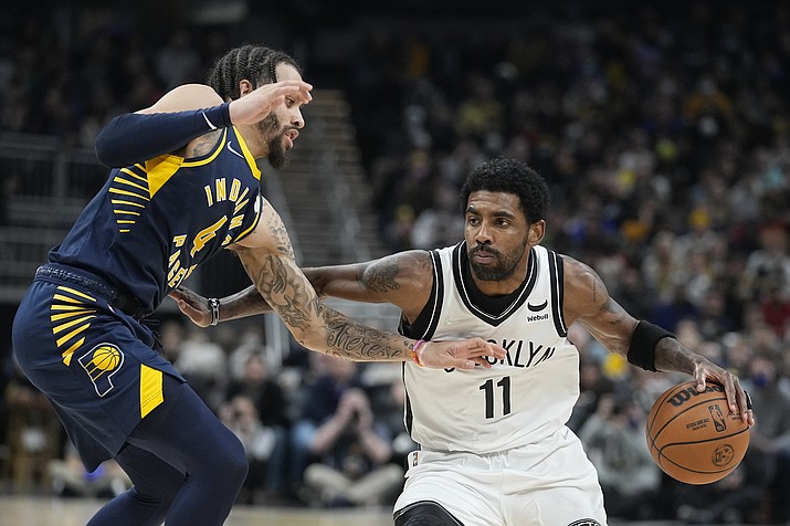 Brooklyn Nets' Kyrie Irving (11) is defended by Indiana Pacers' Duane Washington Jr. (4) during the first half of a game Wednesday, Jan. 5, 2022, in Indianapolis. (Darron Cummings/AP)