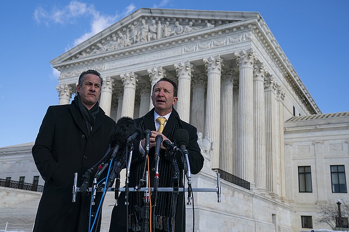 Louisiana Attorney General Jeff Landry talks to reporters outside the Supreme Court after arguments about whether to allow the administration to enforce a vaccine-or-testing requirement that applies to large employers and a separate vaccine mandate for most health care workers, Friday, Jan. 7, 2022, in Washington. At left is deputy Louisiana Attorney General Bill Stiles. (Evan Vucci/AP)