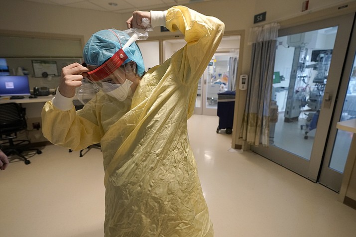 Registered nurse Sara Nystrom, of Townshend, Vt., prepares to enter a patient's room in the COVID-19 Intensive Care Unit at Dartmouth-Hitchcock Medical Center, in Lebanon, N.H., Jan. 3, 2022. The omicron variant has caused a surge of new cases of COVID-19 in the U.S. and many hospitals are not only swamped with cases but severely shorthanded because of so many employees out with COVID-19. (Steven Senne/AP, File)