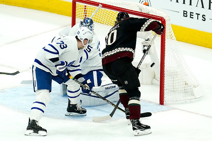 Arizona Coyotes center Ryan Dzingel, right, scores a goal against Toronto Maple Leafs goaltender Petr Mrazek, left, as Maple Leafs defenseman Travis Dermott (23) tries to help out during the first period of a game Wednesday, Jan. 12, 2022, in Glendale. (Ross D. Franklin/AP)