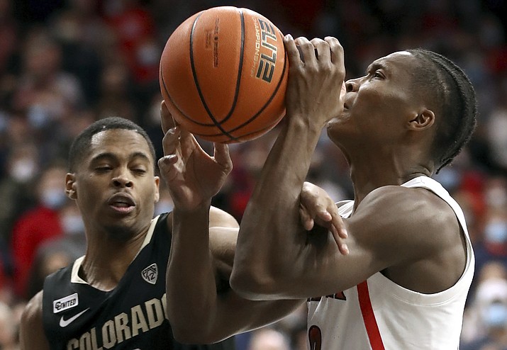 Arizona guard Bennedict Mathurin (0) gets hacked by Colorado guard Keeshawn Barthelemy (3) on his way to the basket during the first half of a game Thursday, Jan. 13, 2022 in Tucson. (Kelly Presnell/Arizona Daily Star via AP)