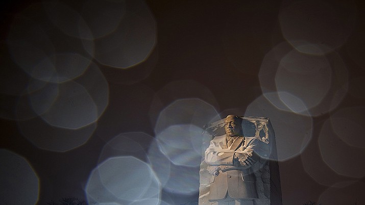 In a long exposure photo, lights from a snowplow illuminate sleet at the Martin Luther King Jr. Memorial in Washington, Sunday, Jan. 16, 2022. Ceremonies scheduled for the site on Monday, to mark the Martin Luther King Jr. national holiday, have been canceled because of the weather. (Carolyn Kaster/AP)