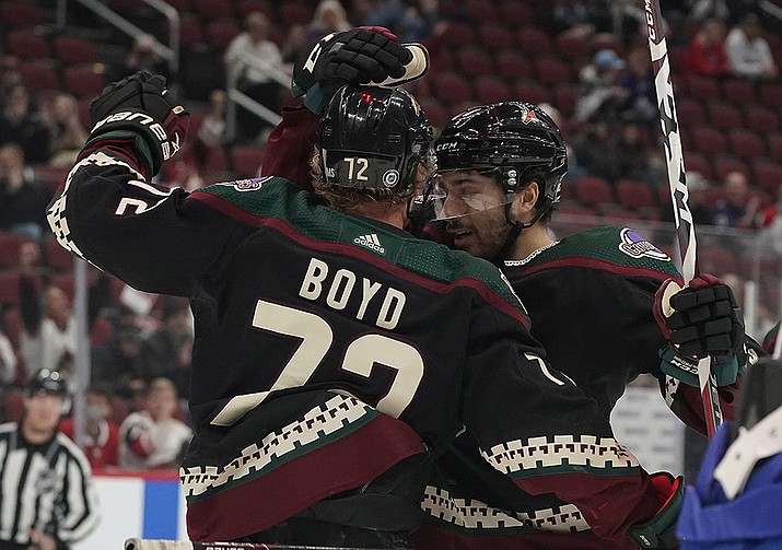 Arizona Coyotes' Nick Schmaltz (8) right, celebrates with Travis Boyd (72) after Boyd's goal against the Montreal Canadiens during the first period of an NHL hockey game Monday, Jan. 17, 2022, in Glendale. (Darryl Webb/AP)