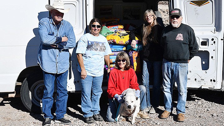 For the Luv of Paws shelter takes receipt of 2,200 pounds of dog and cat food collected by Chris Marie and Butch Meriwether during their annual Halloween and Christmas light displays. From left are For the Luv of Paws volunteer Earl Jones, Santa’s Helper Chris Marie, sanctuary founder and President Cherie DaLynn, Narlette the dog (who was recently adopted), sanctuary worker Debbie Betz and Gary Juneau. (Photo by Butch Meriwether/For the Miner)