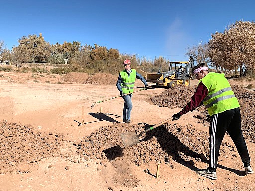 Jeffrey Derrick and Peter Bugala of ASU’s Engineering Projects in Community Service move dirt to shape berms for a new bike track in Tuba City, Arizona. (Photo courtesy of Arizona State University)