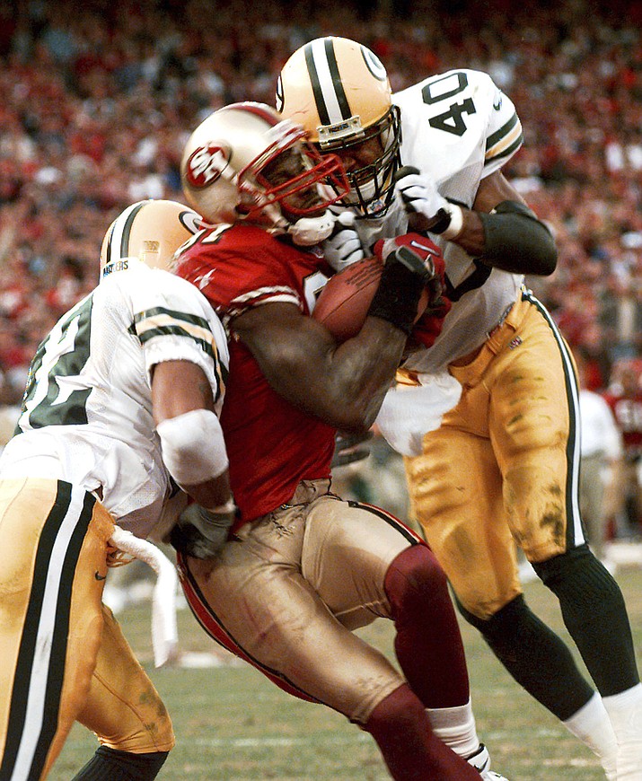 San Francisco 49ers' wide receiver Terrell Owens pulls in a 25-yard touchdown pass from quarterback Steve Young as Green Bay Packers' safeties Pat Terrell (40) and Darren Sharper defend late in the fourth quarter of the NFC wild card playoff game at 3COM Park in San Francisco, Sunday, Jan. 3, 1999. With 8 seconds left and the Niners trailing by four, Young stumbled dropping back from center and then threaded a 25-yard pass between a phalanx of Packers to Owens. (Susan Ragan/AP, File)
