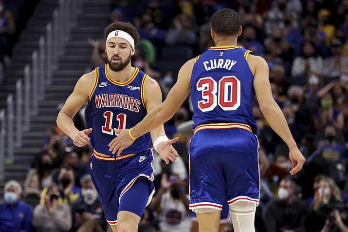 Golden State Warriors guard Klay Thompson (11) is congratulated by guard Stephen Curry (30) after Thompson scored against the Detroit Pistons during the first half of a game in San Francisco, Tuesday, Jan. 18, 2022. (AP Photo/Jed Jacobsohn)