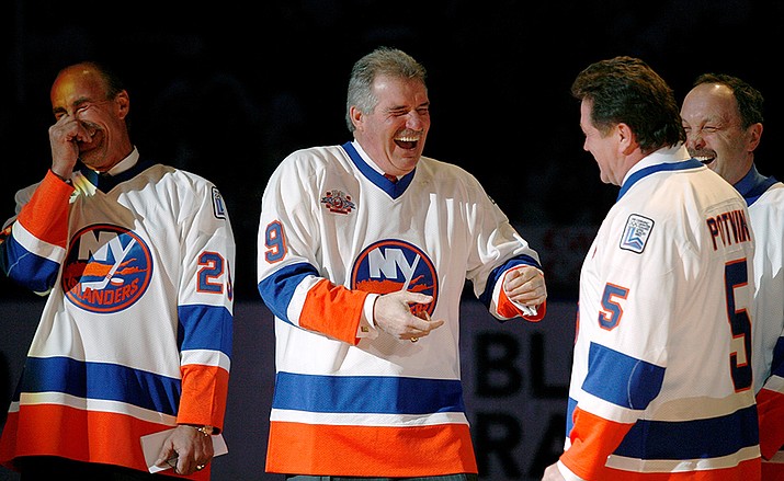 Clark Gillies, second from left, greets Denis Potvin, second from right, as Bryan Trottier, right, and Bobby Nystrom, left, get a chuckle out of the encounter during introductions for "The Core of the Four" New York Islanders teams that won consecutive Stanley Cups from 1979 to 1982, at Nassau Coliseum in Uniondale, N.Y., March 2, 2008. Gillies has died. He was 67. The Islanders announced Gillies' death Friday night, with team president and general manager Lou Lamoriello saying “the entire Islanders community is devastated by the loss.” The team did not say where Gillies died or provide a cause of death. (Kathy Willens, AP File)