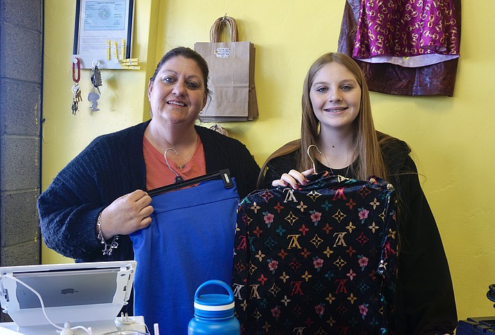 Charlene Flickinger, left, and her eldest daughter, McKenna, hold a couple of clothing items behind the counter at Flickinger’s new clothing store BumbleBee Boutique in Chino Valley on Thursday, Jan. 20, 2022. (Aaron Valdez/Review photo)