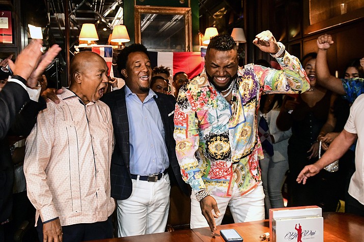 Former Boston Red Sox player David Ortiz, right, celebrates his election to the baseball hall of fame with his father Leo Ortiz, left, and MLB Hall of Fame player Pedro Martinez, center, at the moment of receiving the news in Santo Domingo, Dominican Republic, Tuesday, Jan. 25, 2022. (Manolito Jimenez/AP)
