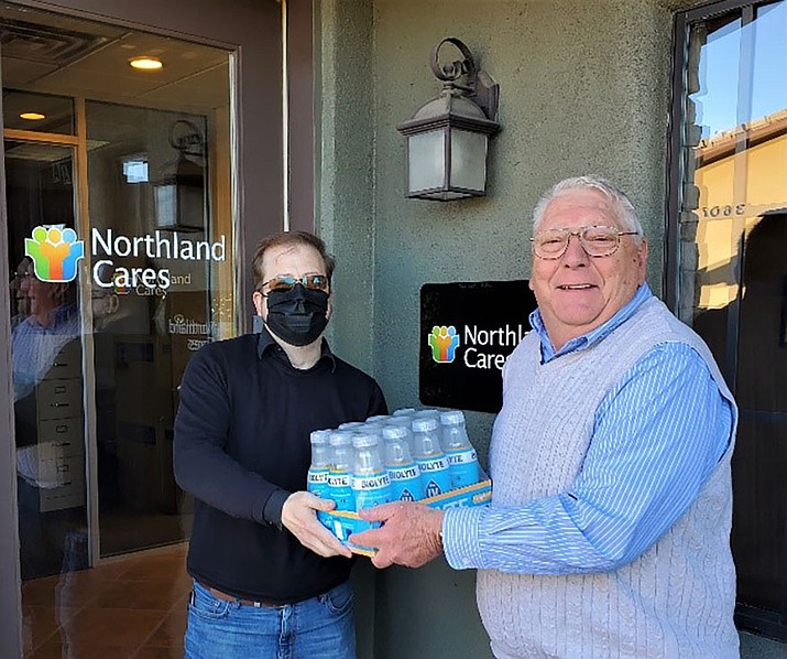 John Duncan of Northland Cares accepts one of four cases of BIOLYTE — a medical grade liquid hydration product — from Bruce Kneeland, representing the Quad City Interfaith Council (QCIC). Northland Cares, located in The Crossings in Prescott, is serving as a donation collection point for this COVID relief effort. (Courtesy)