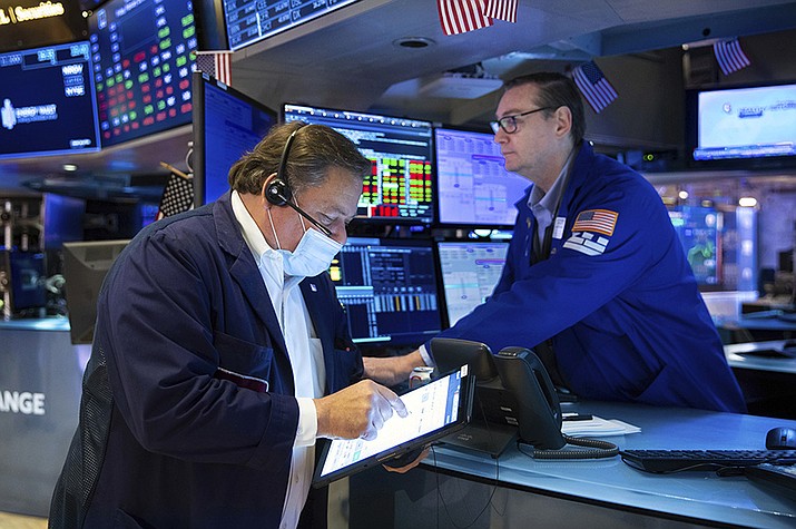 In this photo provided by the New York Stock Exchange, trader John Santiago, left, and specialist Patrick King work on the trading floor, Friday, Feb. 18, 2022. Stocks fell in afternoon trading on Wall Street Friday as major indexes head for their second weekly loss in a row after another bout of turbulence shook markets. (Allie Joseph/New York Stock Exchange via AP)