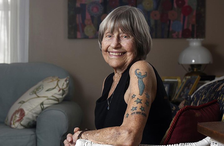 Gloria Weberg shows off a new tattoo on Feb. 3, 2022, at her home in St. Joseph, Mich., that the had added recently to celebrate her 100th birthday. The "NY NY 1922" joins stars symbolizing her seven children as well as a goddess tattoo representing Mother Earth. (Don Campbell/The Herald-Palladium via AP)
