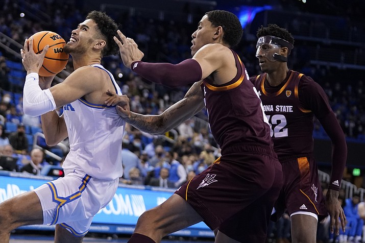 UCLA guard Johnny Juzang, left, drives past Arizona State forward Jalen Graham, center, during the first half of a game Monday, Feb. 21, 2022, in Los Angeles. (Marcio Jose Sanchez/AP)