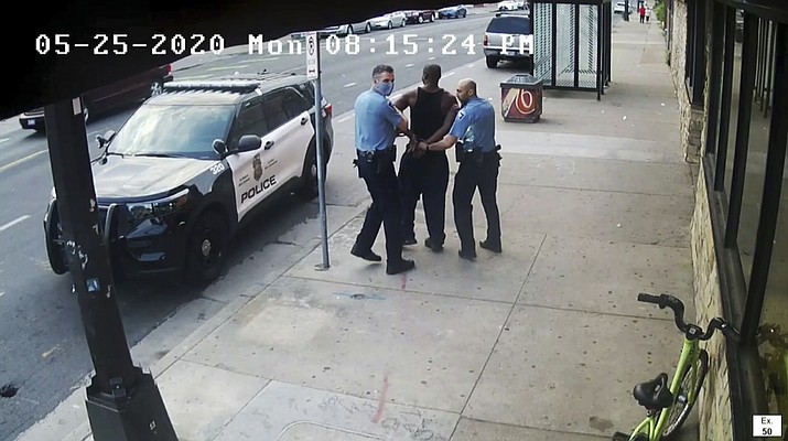 This image from video shows Minneapolis Police Officers Thomas Lane, left and J. Alexander Kueng, right, escorting George Floyd, center, to a police vehicle outside Cup Foods in Minneapolis, on May 25, 2020. The two and another former Minneapolis officers are on trial in February 2022, on federal civil rights charges in Floyd's death. All three are expected to testify. Kueng took the stand Wed. Feb. 16, 2022 in the trial. (Court TV via AP, Pool, File)