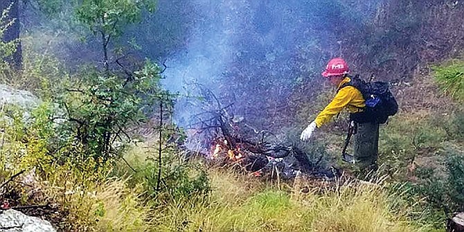 In this undated photo, a firefighter is seen burning debris piles. (Prescott National Forest/Courtesy)