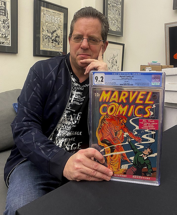 Stephen Fishler, co-owner and CEO of ComicConnect.com, poses for a photo holding up a copy of Marvel Comics #1, Friday, March 18, 2022, in New York. The prized copy of the first-ever Marvel comic book has fetched over $2.4 million in an online auction. (Michael Cohen via AP)