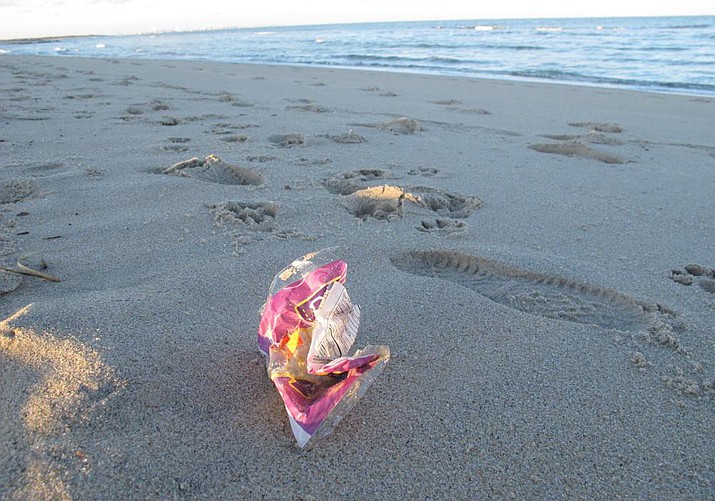 This Feb. 6, 2022 photo shows a discarded snack bag on the sand in Sandy Hook, N.J. The Clean Ocean Action environmental group has said more than 10,000 volunteers picked up over 513,000 pieces of trash from New Jersey's beaches last year, setting a new record. Plastic items accounted for over 82% of the total. (Wayne Parry/AP)