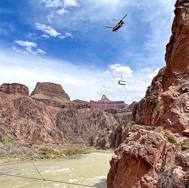 A Chinook helicopter carrying a storage box suspended in a sling load makes its way to Phantom Ranch March 31 as construction continues on the Phantom Ranch waste treatment plant. (NPS Photo/D. Brenchley)