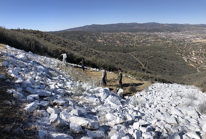 Prescott Recreation Services employees work to paint the large ‘P’ that has overlooked Prescott on Badger Mountain for 100 years. The crew of five repainted the rocks that make up the ‘P’ on Thursday, March 17, 2022. (Cindy Barks/Courier)