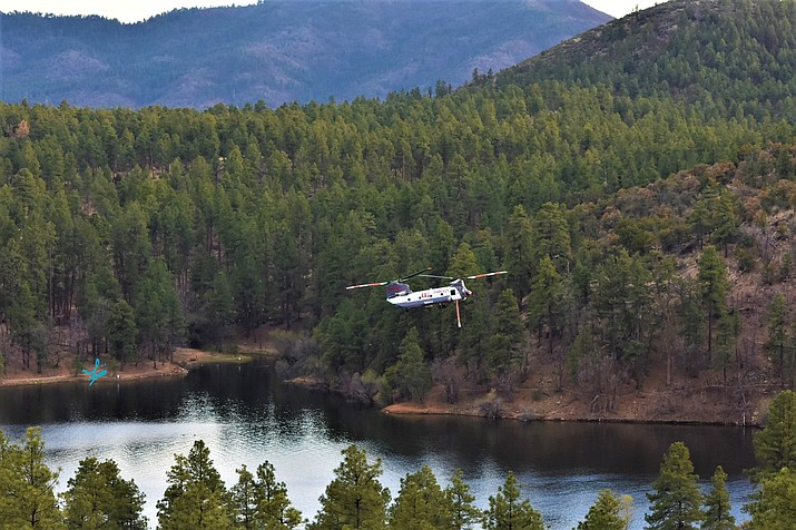 A Chinook chopper is pictured at sunset on Monday, April 18, 2022, approaches Goldwater Lake to collect water to help douse the Crooks Fire, which is burning north of Palace Station. (Laura Flood/Courtesy)