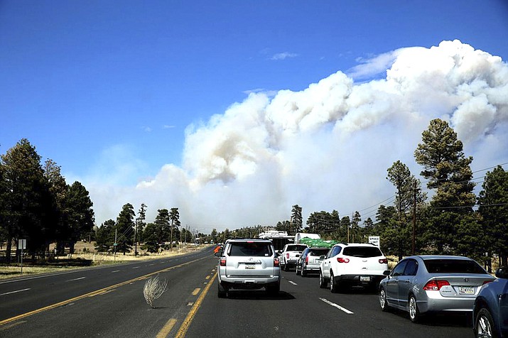 A tumbleweed rolls past a line of cars stopped ahead of a roadblock on U.S. 89 on the outskirts of Flagstaff, Arizona April 19, 2022. An Arizona wildfire doubled in size overnight into Wednesday, a day after heavy winds kicked up a towering wall of flames outside a northern Arizona tourist and college town, ripping through two dozen structures and sending residents of more than 700 homes scrambling to flee. (Jake Bacon//Arizona Daily Sun via AP)