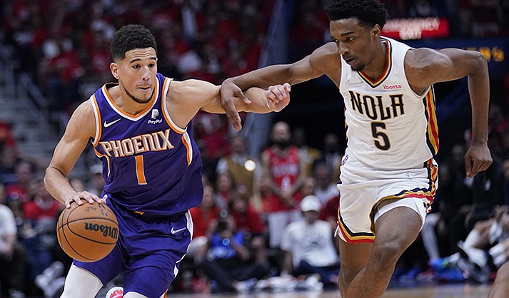 Phoenix Suns guard Devin Booker (1) drives to the basket against New Orleans Pelicans forward Herbert Jones (5) in the second half of Game 6 of an NBA basketball first-round playoff series, Thursday, April 28, 2022 in New Orleans. The Suns won 115-109, to win the series 4-2 and advance to the second-round. (AP Photo/Gerald Herbert)