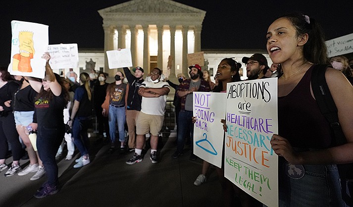 A crowd of people gather outside the Supreme Court, early Tuesday, May 3, 2022 in Washington. (AP Photo/Alex Brandon)
