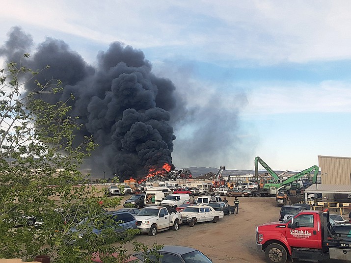 A pile of vehicles and debris burns at about 5:40 p.m. Thursday, May 5, 2022, in the U-Pick-It yard on the east side of Prescott Valley, as fire crews begin to work putting the blaze down. (Tim Wiederaenders/Courier)