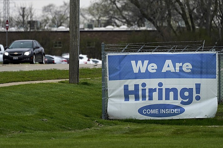 A hiring sign is displayed in Wheeling, Ill., Thursday, May 5, 2022. America’s employers added 428,000 jobs in April, extending a streak of solid hiring that has defied punishing inflation, chronic supply shortages, the Russian war against Ukraine and much higher borrowing costs. (Nam Y. Huh/AP)