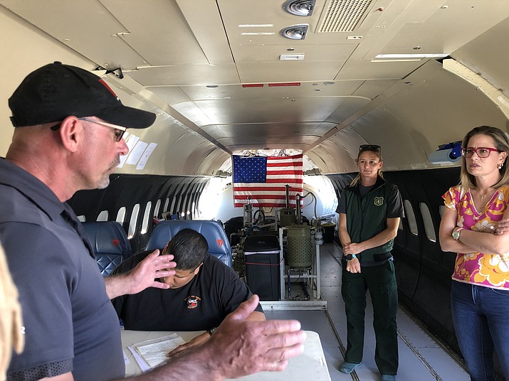 Vince Swinney, left, pilot with Areoair, talks to U.S. Sen. Kyrsten Sinema, right, on Friday, May 6, 2022 on an Areoair air tanker that was located at the Prescott Regional Airport, while Julie Podany of the U.S. Forest Service’s Prescott Fire Center looks on. (Cindy Barks/Courier)