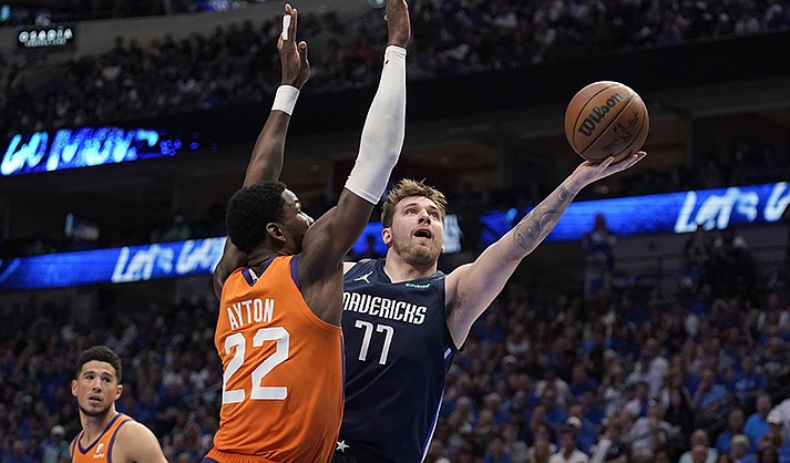 Phoenix Suns center Deandre Ayton (22) defends as Dallas Mavericks guard Luka Doncic (77) shoots in the second half of Game 4 of an NBA basketball second-round playoff series, Sunday, May 8, 2022, in Dallas. (AP Photo/Tony Gutierrez)
