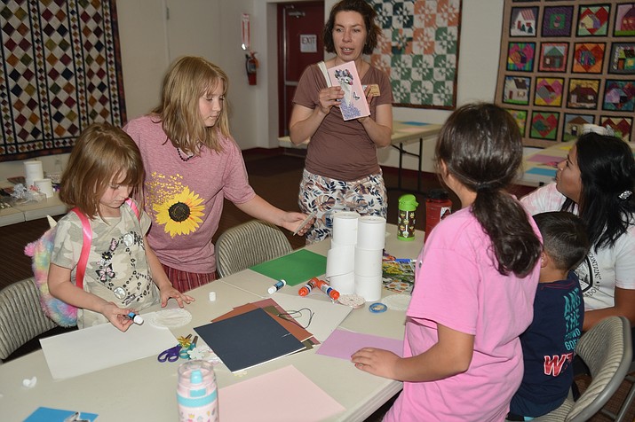 Children’s Librarian Rebecca Laurence, center, guides families at the Mother’s Day card workshop at Chino Valley Public Library, on Friday, May 6, 2022. (Jesse Bertel/Review)