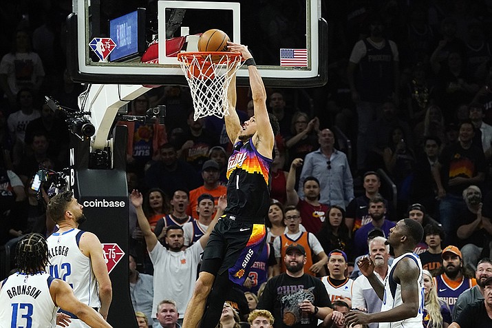 Phoenix Suns guard Devin Booker (1) dunks against Dallas Mavericks guard Jalen Brunson (13), Mavericks forwards Maxi Kleber (42) and Dorian Finney-Smith, right, during the first half of Game 5 of an NBA basketball second-round playoff series Tuesday, May 10, 2022, in Phoenix. (Ross D. Franklin/AP)