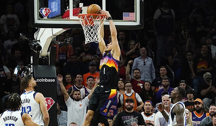 Phoenix Suns guard Devin Booker (1) dunks against Dallas Mavericks guard Jalen Brunson (13), Mavericks forwards Maxi Kleber (42) and Dorian Finney-Smith, right, during the first half of Game 5 of an NBA basketball second-round playoff series Tuesday, May 10, 2022, in Phoenix. (AP Photo/Ross D. Franklin)