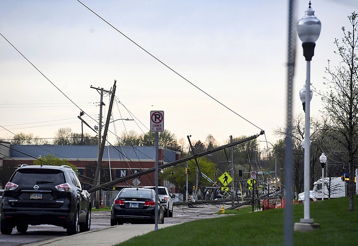 Live power lines and electricity poles fall into the street on Augustana University's campus on Thursday, May 12, 2022, in Sioux Falls, S.D. Strong winds and possible tornadoes caused widespread damage in parts of the Midwest. (Erin Woodiel /The Argus Leader via AP)