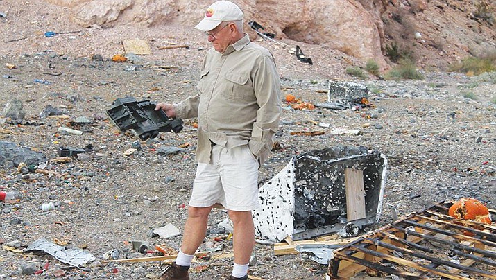 Rodger Melton shows the kind of trash that gets dumped in the desert near Paso De Oro Drive in Lake Havasu City in 2014. (Photo by Today’s News-Herald/For the Miner)
