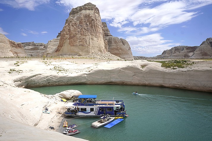 A houseboat rests in a cove at Lake Powell near Page, Arizona. Federal water officials have announced that they will keep hundreds of billions of gallons of Colorado River water inside Lake Powell instead of letting it flow downstream to southwestern states and Mexico. U.S. Assistant Secretary of Water and Science Tanya Trujillo said May 3, that the move would allow the Glen Canyon Dam to continue producing hydropower while officials strategize how to operate the dam with a lower water elevation. (AP Photo/Rick Bowmer, File)