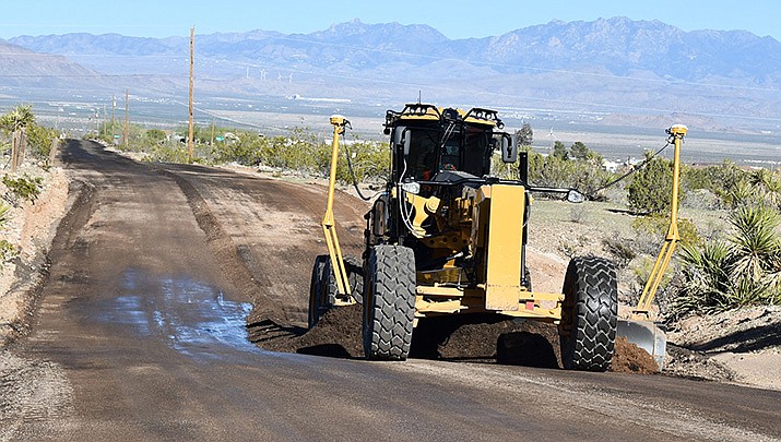 A Petro Rock employee from Utah uses a road grader to apply millings onto Tapeats Drive. (Photo By Butch Meriwether/For the Miner)