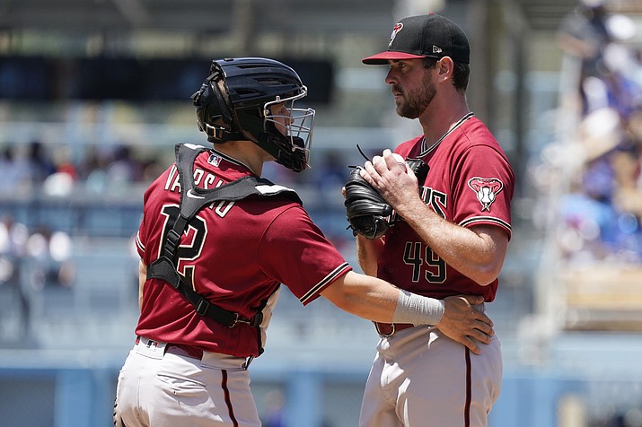 Arizona Diamondbacks starter Tyler Gilbert, right, gets a visit to the mound by catcher Daulton Varsho (12) after Gilbert gave up a solo home run to Los Angeles Dodgers’ Trea Turner during the sixth inning of the first game of a doubleheader Tuesday, May 17, 2022, in Los Angeles. (Marcio Jose Sanchez/AP)