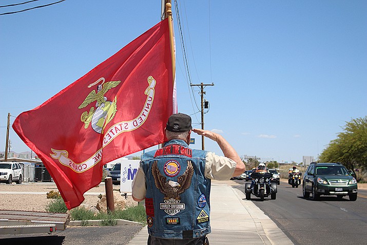 Approximately 270 motorcycles stopped in Kingman on their way to Washington D.C. to honor veterans, including Prisoners of War, Missing in Action and Killed in Action. A man salutes riders as they pull into the parking lot of Mother Road Harley Davidson at 2501 Beverly Ave. in Kingman for lunch. (Photos by MacKenzie Dexter/Kingman Miner)