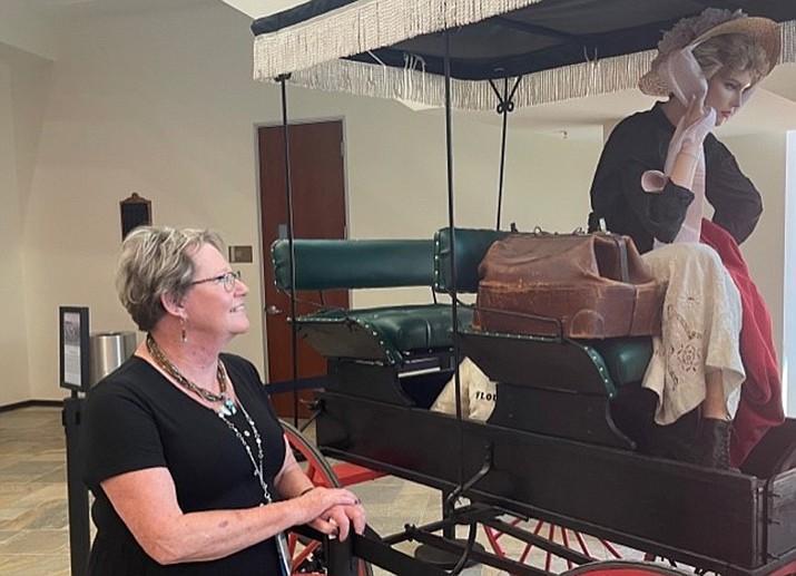 Mohave County Public Fiduciary Carole Collins admires the surrey, on loan from the Mohave County Museum of History and Arts, currently on display in the lobby of the County Administration Building. (Courtesy photo)
